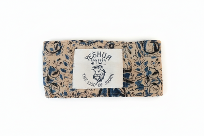 Floral-patterned clutch bag with a lion emblem and text on a textured surface
