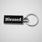 Keychain with 'Blessed' text on a textured gray background
