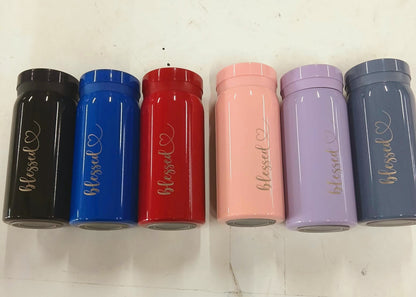 Six cylindrical containers in black, blue, red, pink, purple, and gray with 'blessed' text on a white background.